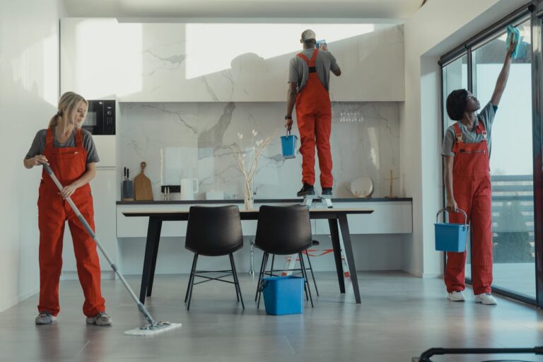 Commercial cleaning crew mopping and wiping a polished office lunchroom in a modern commercial building
