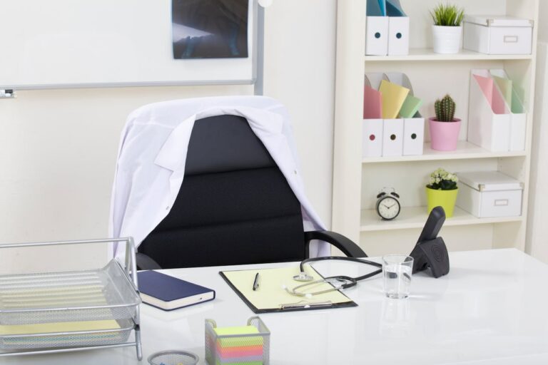 Clean, professional cosmetic surgery consultation room with a desk, neutral decor, and natural light